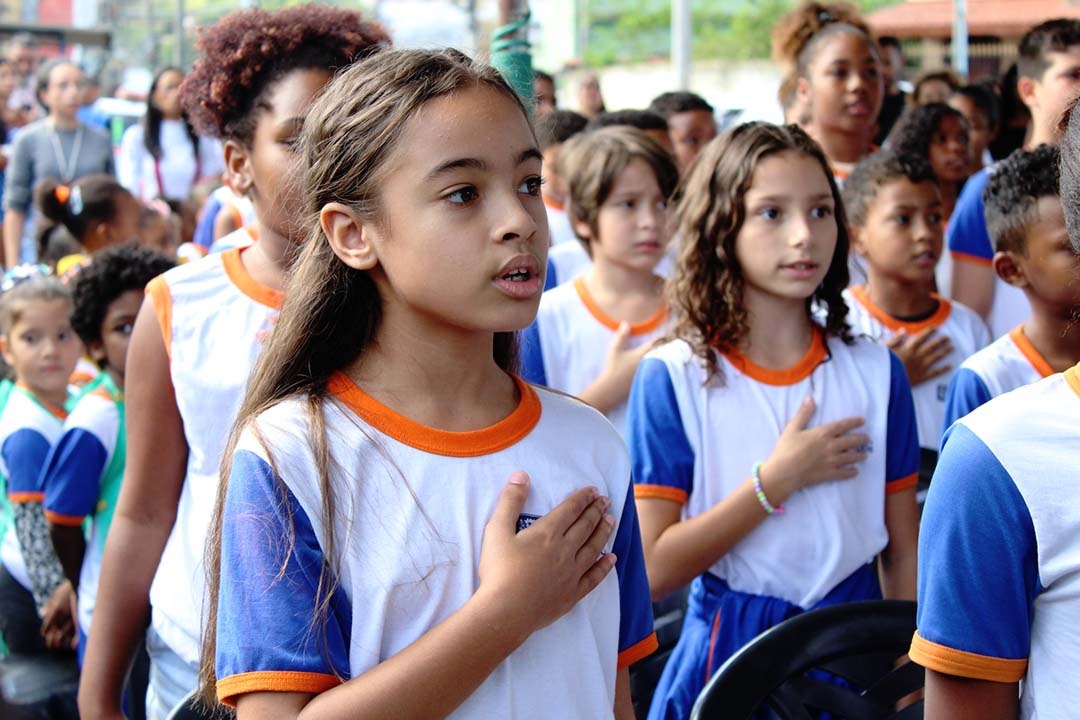 Estudantes entoando o Hino Municipal de Queimados